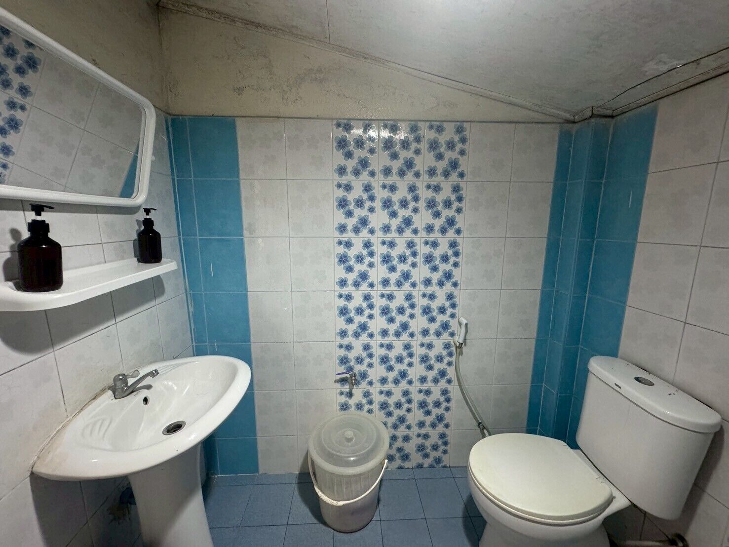 A bathroom with a white sink, a toilet, and a shower area.