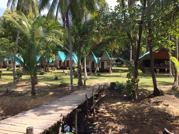 A tropical resort with wooden walkways, palm trees, and bungalow-style accommodations. - Libong Beach Resort (Ko Libong)