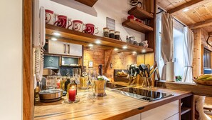 A kitchen with wooden countertops, a stove, and various kitchen utensils.