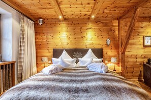 A wooden-paneled room with a bed, pillows, a lamp, and a wall-mounted light fixture. - Studio 'Hüttentraum' with Mountain View, Private Terrace and Wi-Fi (Inzell)