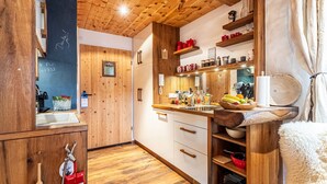 A wooden interior with a kitchen area, wooden cabinets, and a sink.
