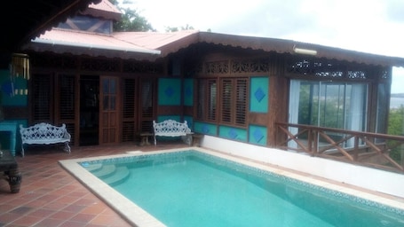 Una piscina al aire libre, sillones reclinables de piscina