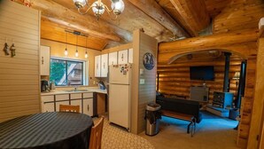 Ein gemütliches Blockhaus-Interieur mit Küche, Essbereich und Wohnbereich.