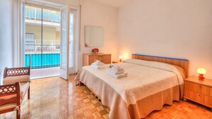 A bedroom with a bed, bedside table, nightstand, and a view of a balcony. - Casa Letizia few min from sea outdoor dining for 4, Sanremo, Italy (Sanremo)