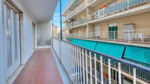 A residential building with multiple balconies, a tiled corridor, and a green awning. - Casa Letizia few min from sea outdoor dining for 4, Sanremo, Italy (Sanremo)