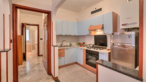 A modern kitchen with light blue cabinets, a stainless steel refrigerator, and a built-in oven. - Casa Letizia few min from sea outdoor dining for 4, Sanremo, Italy (Sanremo)