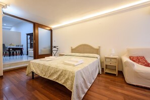 A bedroom with a bed, bedside tables, a chair, and a wardrobe.