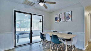 A dining area with a wooden table, blue chairs, and a ceiling fan. - 5BR, 3BA Spacious N. Columbus Villa w/Hot Tub, BBQ, Play Area, 13 mi. to Benning (Columbus)