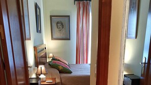 Une chambre à coucher comprenant un lit, des tables de chevet, un bureau et une armoire.