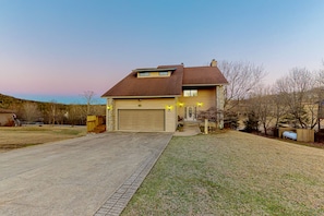 A two-story house with a garage, a front yard, and a driveway.