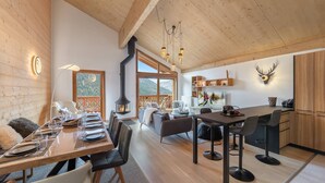 Et moderne interiør med træloft, pejs, spiseområde og opholdsstue.