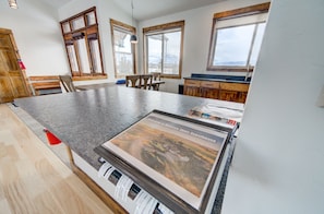 A spacious kitchen with a granite countertop, wooden cabinets, and large windows offering views of the outdoors. - Montana Skies, Livingston, MT! Skiing / Fishing / Yellowstone! (Livingston)