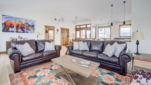 A spacious living room with two leather sofas, a wooden coffee table, and a colorful rug. - Montana Skies, Livingston, MT! Skiing / Fishing / Yellowstone! (Livingston)