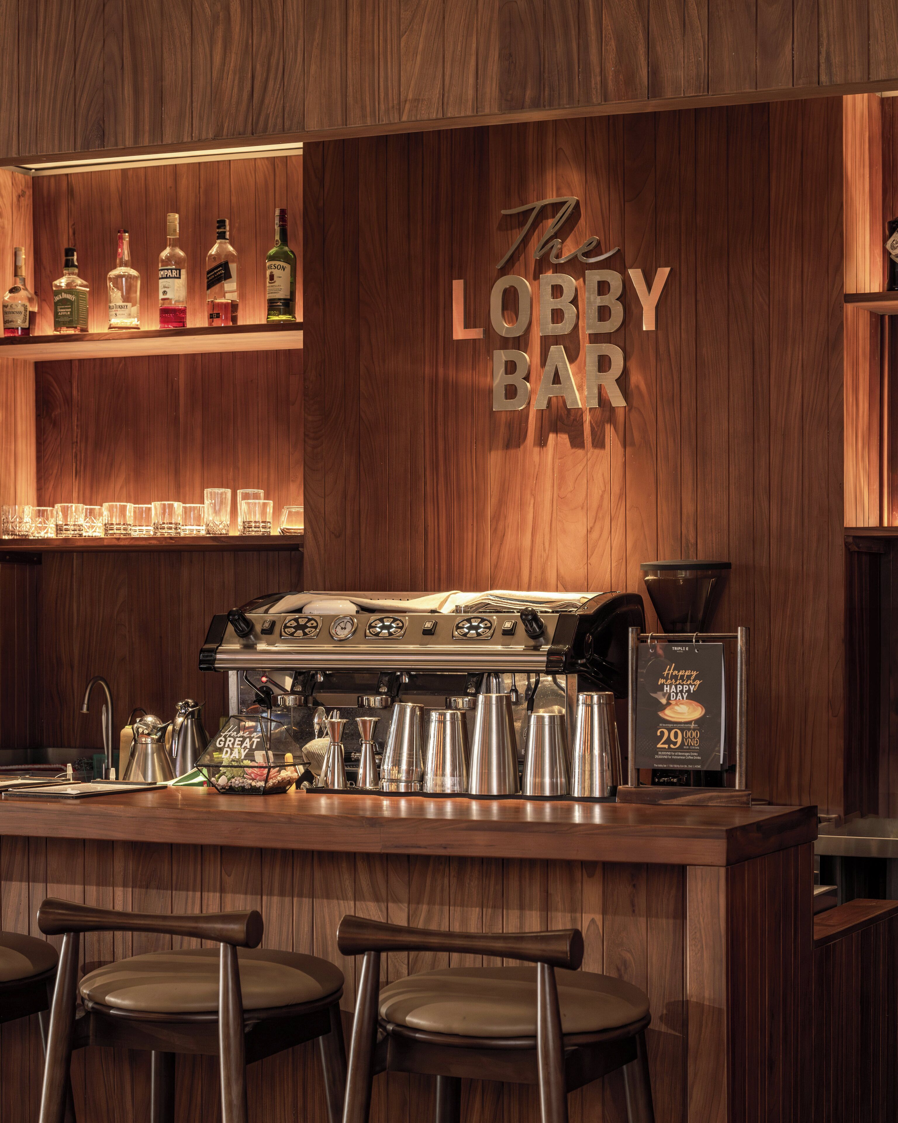 A bar with a wooden interior, a coffee machine, and several bottles of liquor.