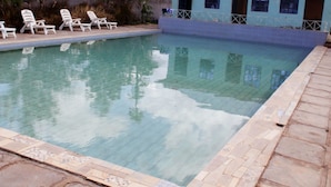 A swimming pool with lounge chairs and a tiled deck. - Lapset Hotel (Isiolo)