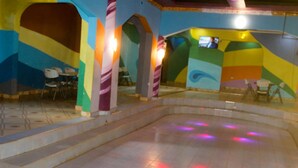 A colorful indoor space with a central open area and seating around the perimeter. - Lapset Hotel (Isiolo)