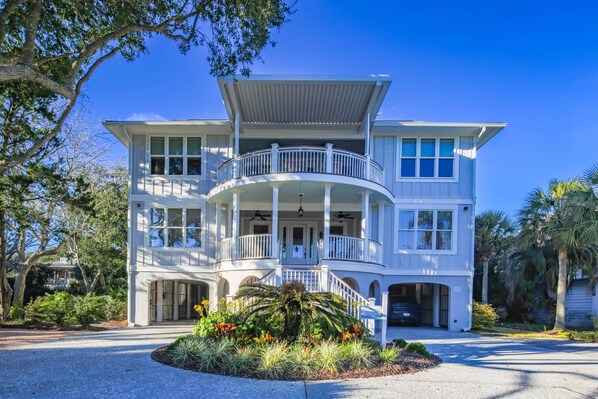 A two-story house with a balcony, a covered porch, and a driveway.