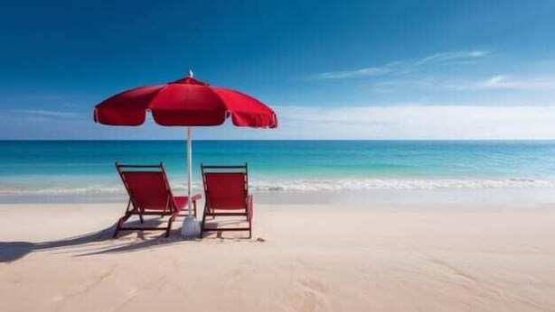 Een strand met twee rode stoelen en een rode parasol.