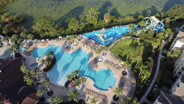 A resort with multiple swimming pools, a water park, and a well-maintained landscape with palm trees. - Resort Home 3.5 miles to Disney with home theater (Kissimmee)