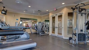 A gym with treadmills, elliptical machines, and weightlifting equipment. - Resort Home 3.5 miles to Disney with home theater (Kissimmee)