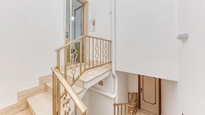 Una escalera con barandilla de madera y una puerta al final.