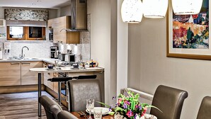 A modern kitchen with a dining area, wooden cabinets, and a large window. - 2 bedroom accommodation in Balmaha (Balmaha)