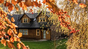 A wooden cabin with a sloped roof, a front door, and a small porch. - 2 bedroom accommodation in Balmaha (Balmaha)