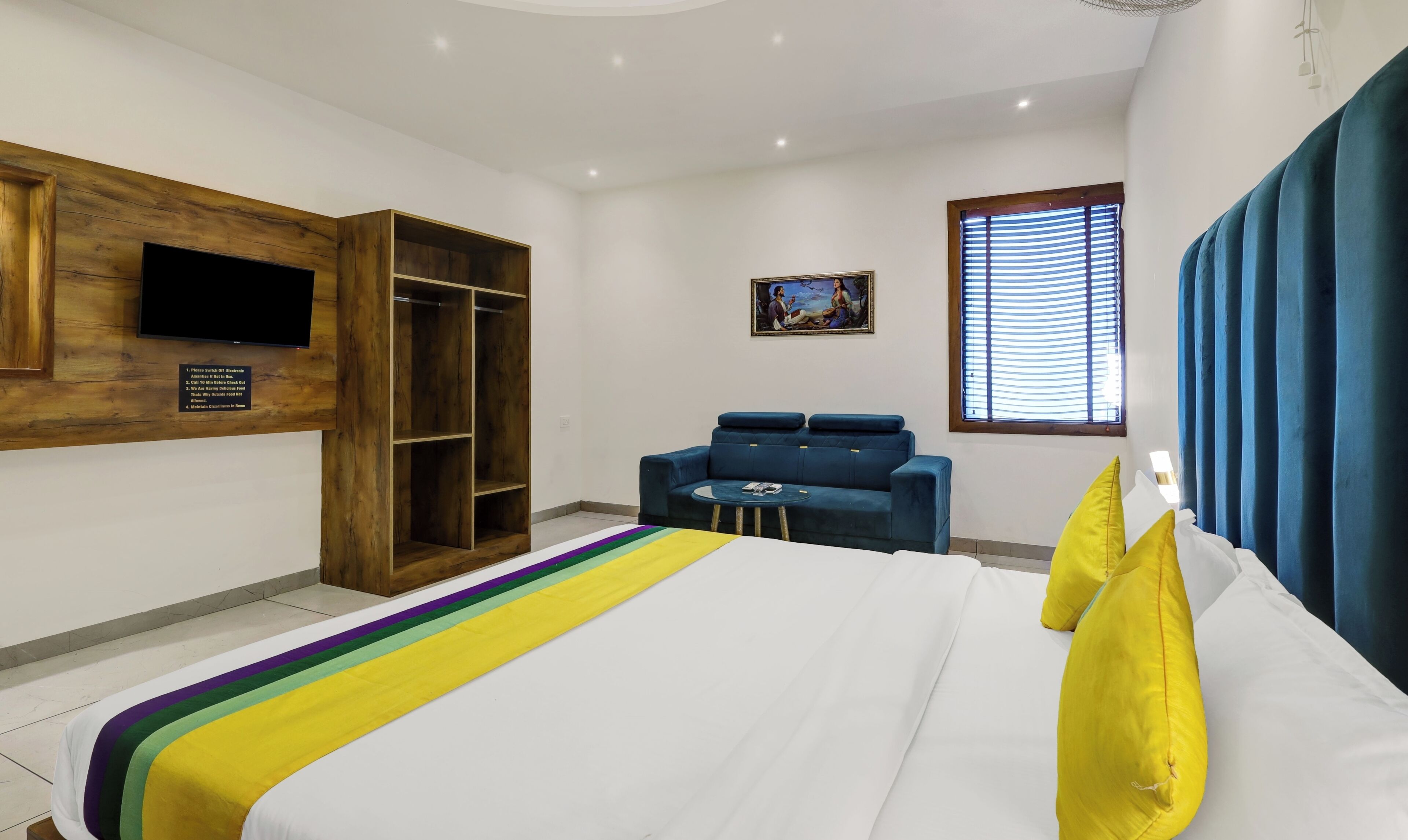 A bedroom with a bed, a wardrobe, a sofa, a TV, and a window with curtains.