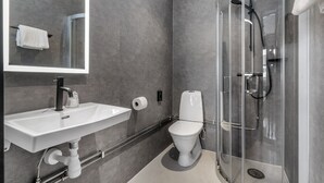 A modern bathroom with a glass-enclosed shower, a white sink, and a toilet.