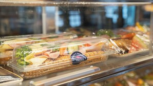 A display case with various food items, including sandwiches and salads, in a restaurant or cafeteria setting.