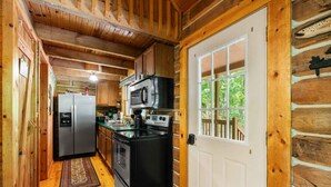 A compact kitchen with a refrigerator, stove, and microwave. - Great Location 4 minutes from Patoka Lake Entrance with Hot Tub! (Birdseye)