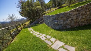 A stone pathway leading uphill, surrounded by grass and trees. - House Geranio  in Tuscany (LUCCA) with Pool, garden and spectacular sea view  (Toscana)