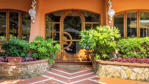 A building entrance with a stone wall, a wooden archway, and potted plants. - House Geranio  in Tuscany (LUCCA) with Pool, garden and spectacular sea view  (Toscana)