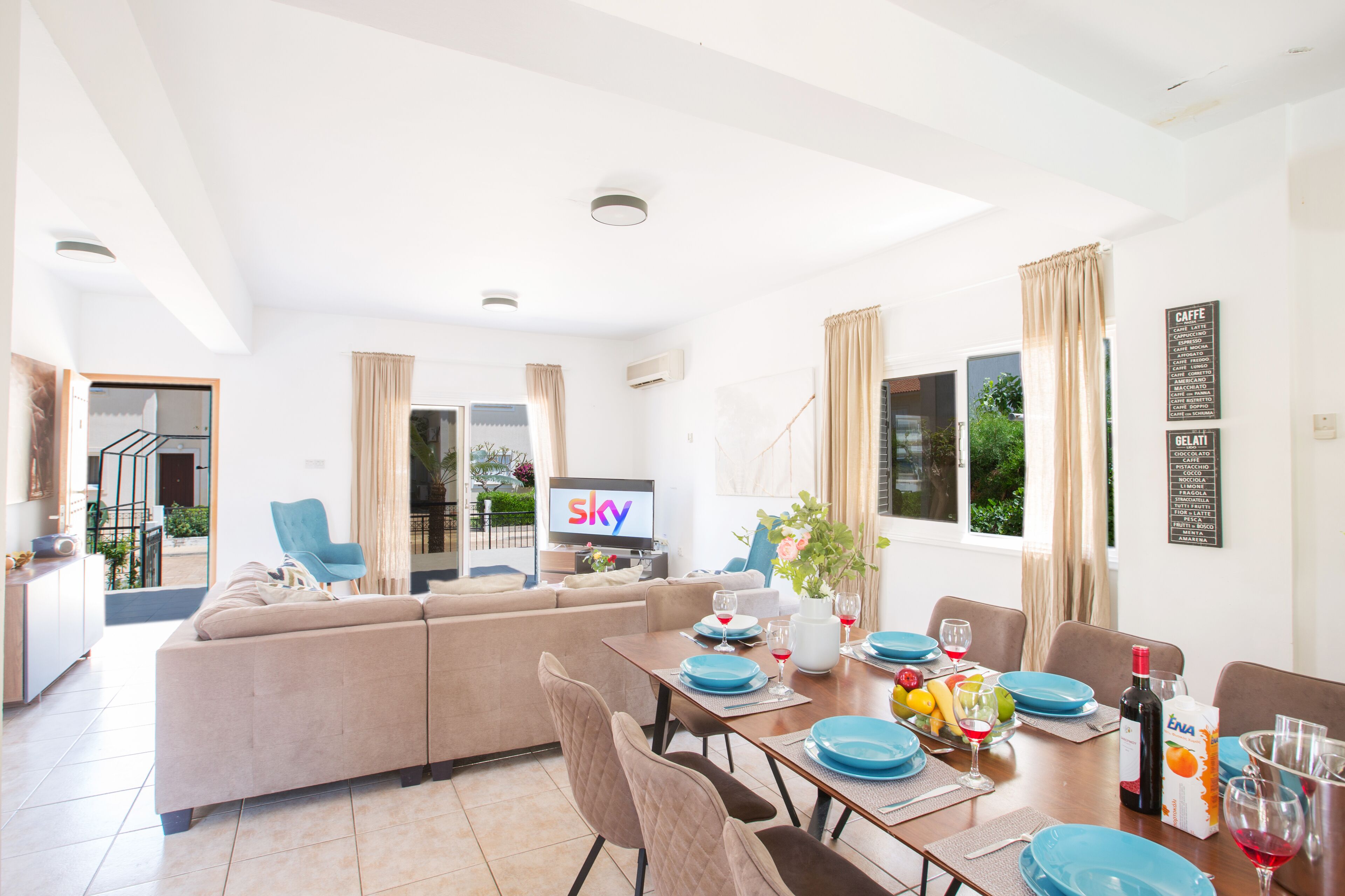 A modern living room with a sofa, dining table, and TV.