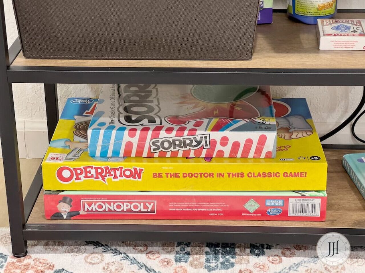Una estantería con tres juegos de mesa: Operation, Sorry!, y Monopoly.