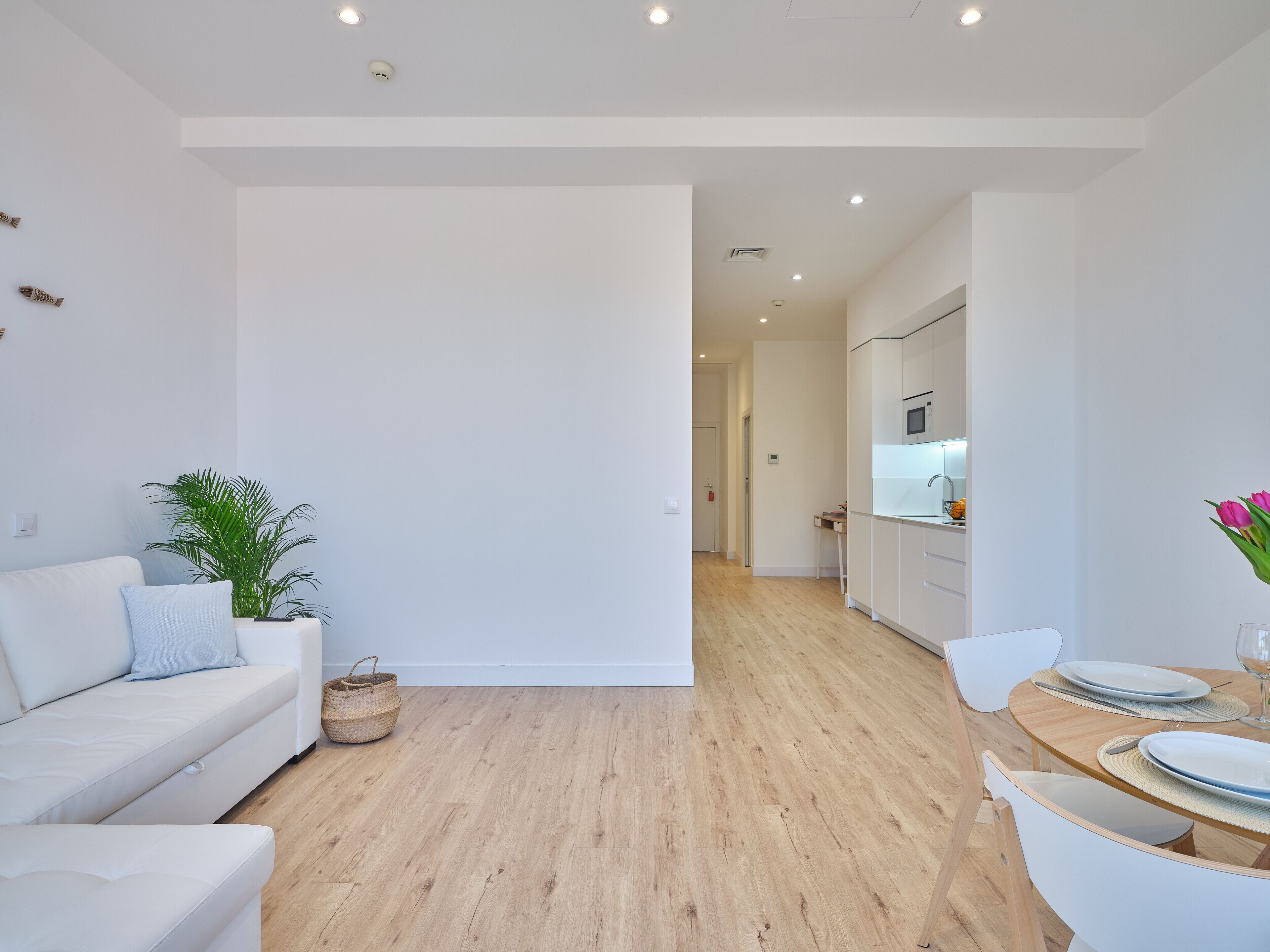 A modern apartment with a living area, kitchen, and dining space.
