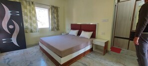 A bedroom with a bed, nightstands, a wardrobe, and a large abstract artwork on the wall. - LakeBreeze By Sunrise (Nainital)