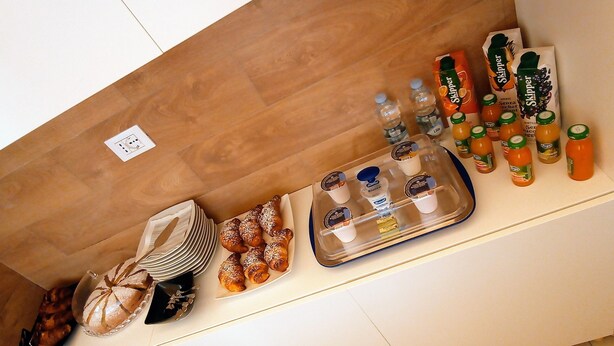 Een ontbijtbuffet met gebak, drankjes en toevoegingen.