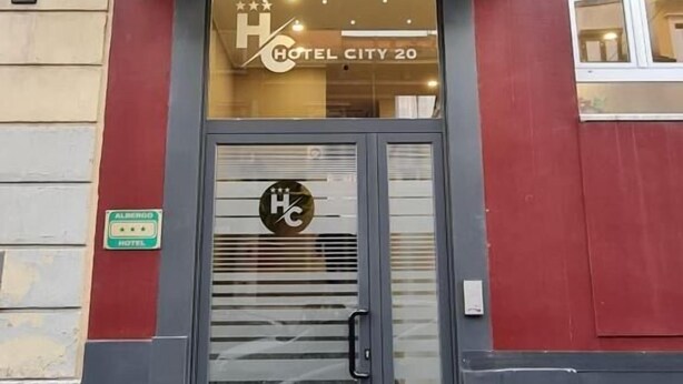 The exterior of City 20 Hotel with a black awning, a glass door with a logo, and a number '9' sign on the building. - Hotel City 20 (Milan)