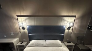 A hotel room with a large bed, two bedside tables, a desk, and a chair. - Hotel City 20 (Milan)