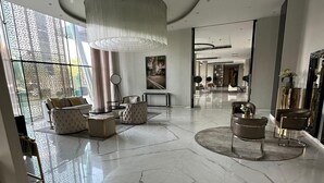 A spacious lobby with marble flooring, modern furniture, and a large chandelier. - DAMAC Towers Riyadh داماك تاورز الرياض (Riyadh)