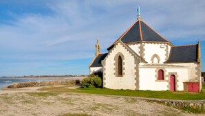 A small, white church with a red door and a stone pathway leading to it. - Charme de Penvins by Interhome (Sarzeau)