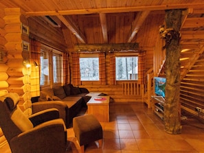 A log cabin interior with a sofa, chairs, a coffee table, and a television. - Petsankolo by Interhome (Pelkosenniemi)