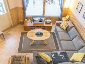 Un salon avec un canapé, une table basse et un téléviseur.