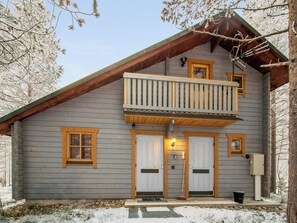 A two-story cabin with a balcony, two doors, and a small porch area. - Pyhä-kohu by Interhome (Pelkosenniemi)