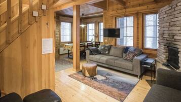 Un intérieur en bois avec un canapé, une table et une cheminée.
