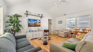 A living room with a sofa, armchair, coffee table, and a potted plant. - 2 Bedroom Condo Only Steps to the Beach! (North Wildwood)