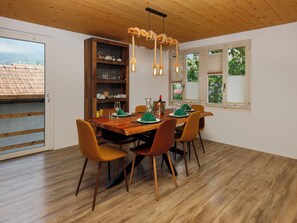 A dining area with a wooden table, six chairs, and a chandelier.
