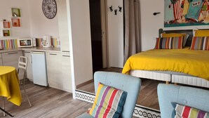 A bedroom with a bed, a desk, a chair, and a painting on the wall. - PALMIER *** studio with garden and parking (Le Bois-Plage-en-Ré)