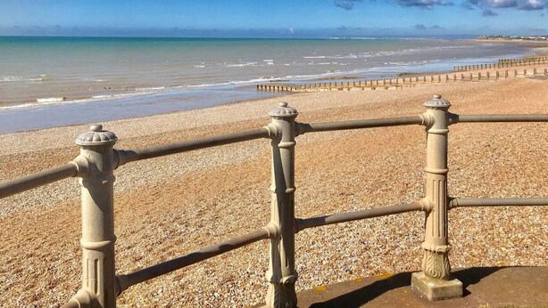 A beach with a pebble shore, a metal railing, and the ocean in the background. - Beachfront Apartment With Woodburner & Courtyard (St Leonards-On-Sea)